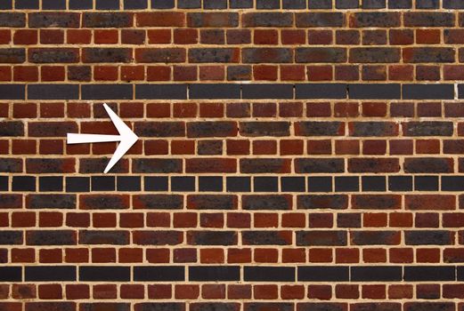 An arrow pointing the right direction on brick wall