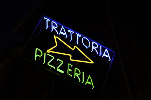 Trattoria and pizzeria neon sign in the night