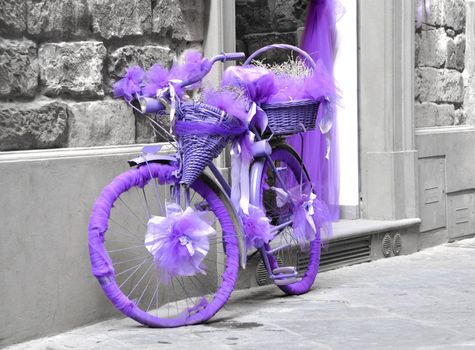 Vintage bicycle wrapped in purple fabric, black and white background