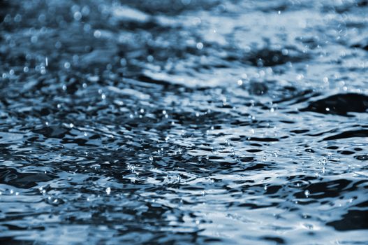 Water droplets floating on the dark blue water surface