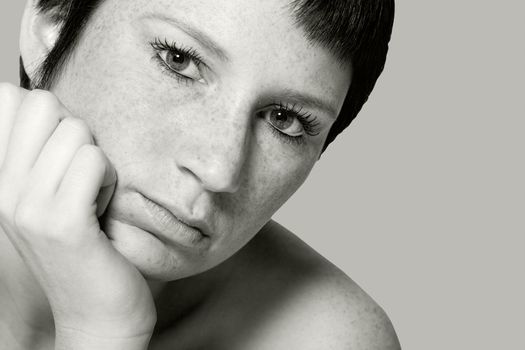 Studio portrait of a young woman with short hair looking bored