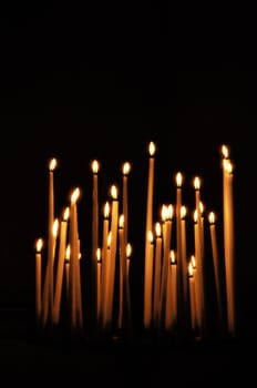 Candles in a church, black background