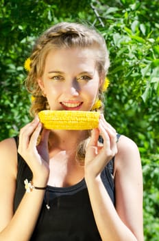 Close-up outdoor portrait of young beauty woman eating corn-cob