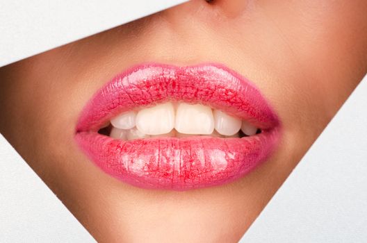 Beautiful female lips closeup behind silver metal background