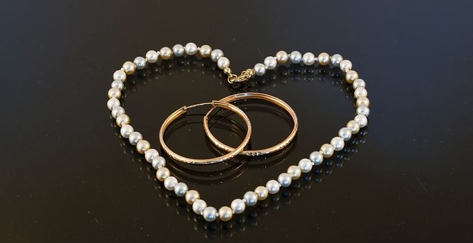 Beads in the shape of a heart with two rings on a black background