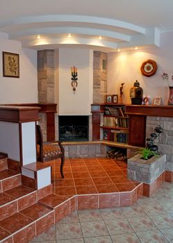 Fireplace in a hall. Hours, a picture, mahogany, a tile.
