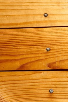 Fragment of new lacquered wooden panel with nails sealed