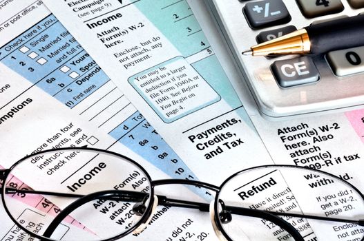 Business concept. Financial papers with calculator, glasses and pen.