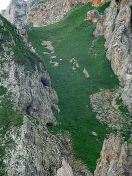 Mountains; rocks; a relief; a landscape; a hill; a panorama; Caucasus; top; a slope; clouds; the sky; a landscape