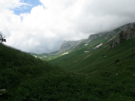 Mountains; rocks; a relief; a landscape; a hill; a panorama; Caucasus; top; a slope; clouds; the sky; a landscape