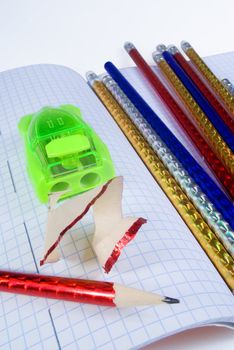 Multi-colored pencils and yellow sharpener