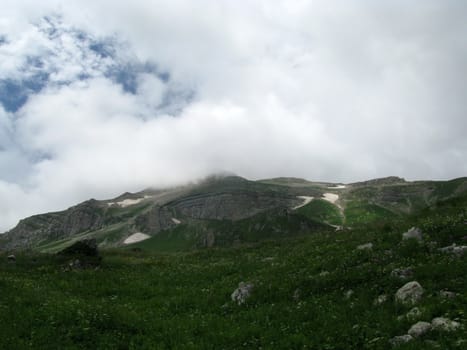 Mountains; rocks; a relief; a landscape; a hill; a panorama; Caucasus; top; a slope; clouds; the sky; a landscape