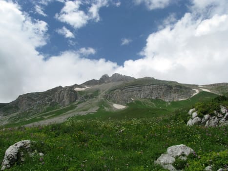 Mountains; rocks; a relief; a landscape; a hill; a panorama; Caucasus; top; a slope; clouds; the sky; a landscape