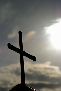 Silhouette of a cross against dramatic morning sky