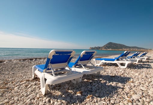 Deckchairs waiting for sunbathers on a warm Mediterranean beach