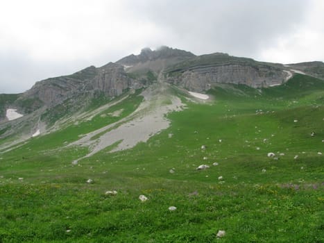 Mountains; rocks; a relief; a landscape; a hill; a panorama; Caucasus; top; a slope; clouds; the sky; a landscape