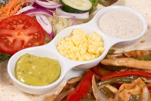 Chicken fajitas served with several dip sauces