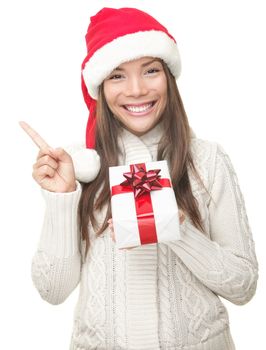 Christmas woman pointing up to the side at copy space. Isolated on white background. Beautiful young smiling woman in Santa hat and sweater showing empty copyspace. Asian / Caucasian female model.