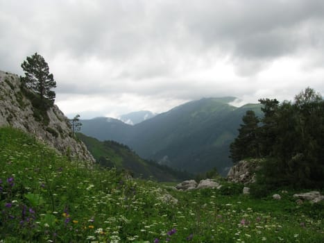 Mountains; rocks; a relief; a landscape; a hill; a panorama; Caucasus; top; a slope; clouds; the sky; a landscape