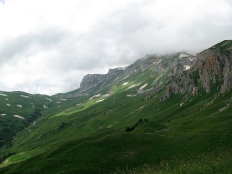 Mountains; rocks; a relief; a landscape; a hill; a panorama; Caucasus; top; a slope; clouds; the sky; a landscape