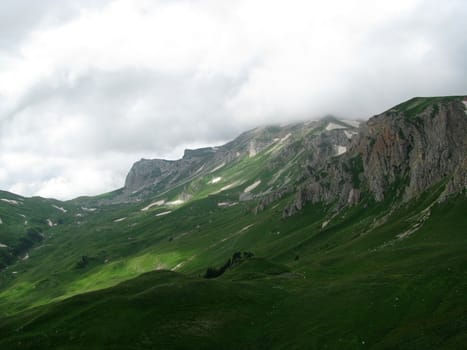 Mountains; rocks; a relief; a landscape; a hill; a panorama; Caucasus; top; a slope; clouds; the sky; a landscape