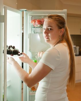 young woman getting food out of fridge for a late night snack