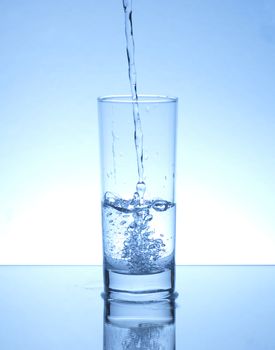 Glass of water on blue background