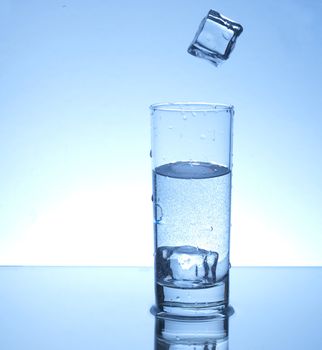 Ice cube falling in a glass of water