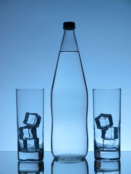 Bottle of water and two glasses with ice on blue