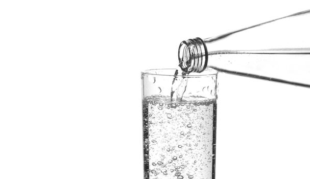 Sparkling water being poured from the neck of a bottle, close-up