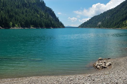 summer panoramic view of alpine lake, Agaro artificial lake, Italy