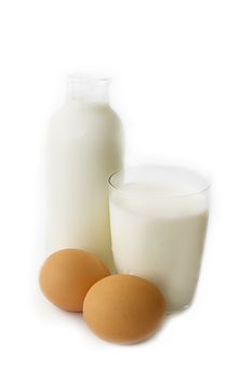 Bottle and glass of milk with eggs on white