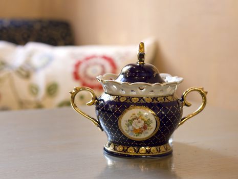 Vintage style Chinese porcelain sugar bowl on table in retro cafe. 