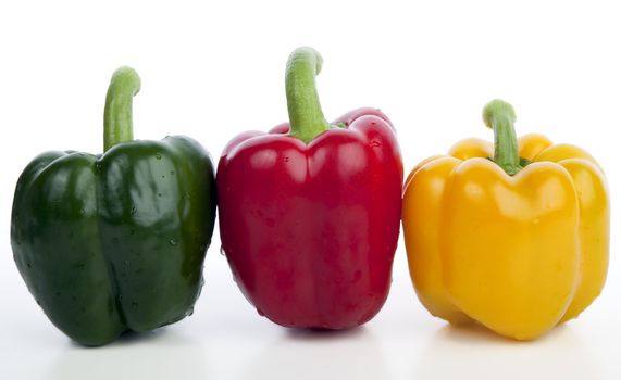 Red yellow and green bell peppers isolated on white.