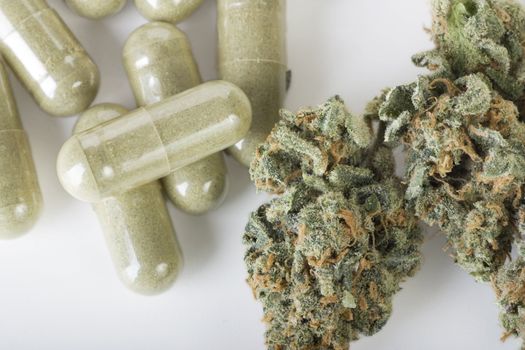 Dried marijuana and green capsules. 