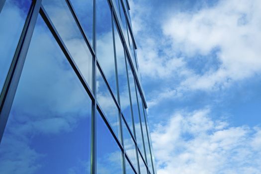 Clouds and blue sky reflection in glass skyscraper