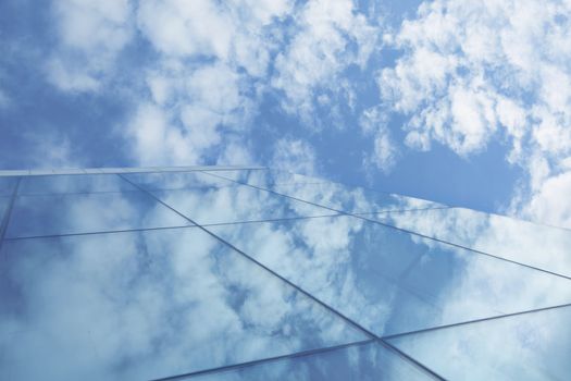 Clouds and blue sky reflection in glass skyscraper