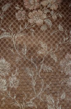Vintage close up of a brown fabric background with flowers