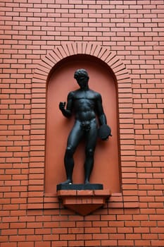 the black statue on orange wall 