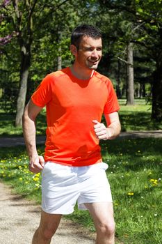 young man running in a park in spring