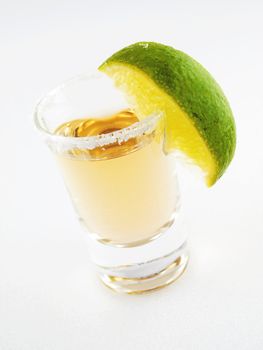 Shot of tequla with a piece of green lime