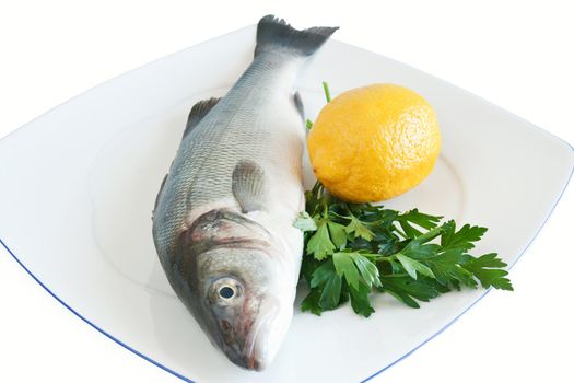 plate with sea bass, lemon and parsley isolated on white background with clipping path