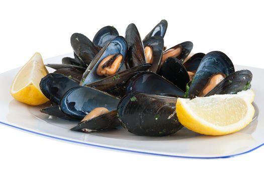 cooked mussels on a plate with lemon isolated with clipping path