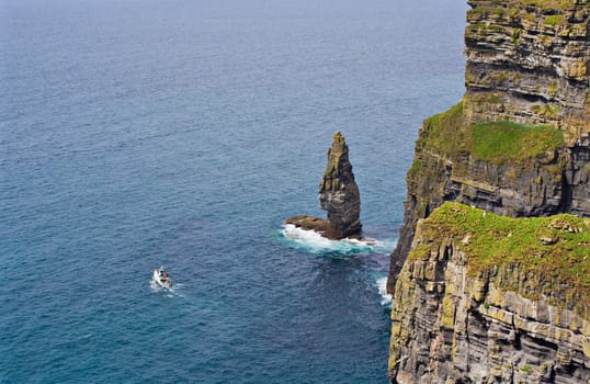 The Cliffs of Moher in Ireland with a boat in the Atlantic Ocean