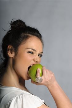 Beautiful young woman biting an apple portrait isolated