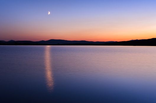 The Pablo National Wildlife Refuge and the moon at twilight, Lake County, Montana, USA