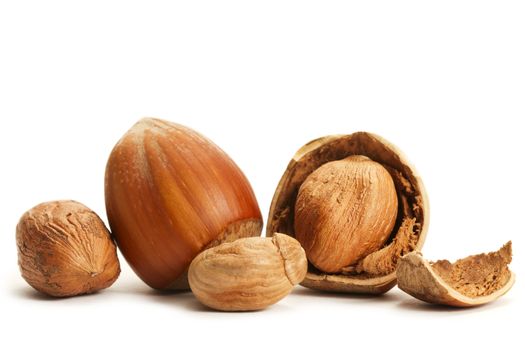 some closed and cracked hazelnuts on white background