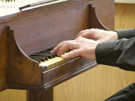 hands playing virginal harpsichord