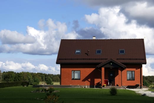 The red house on a background of the sky and clouds