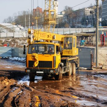 The truck crane goes from building on a spring dirt